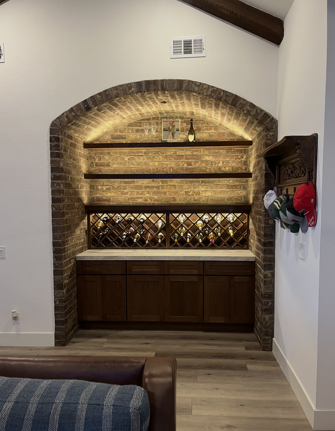 Brick archway wine nook with built-in wine rack and cabinetry